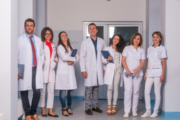 Group of medical staff, team doctors and nurses posing in the hallway of a hospital, clinic.