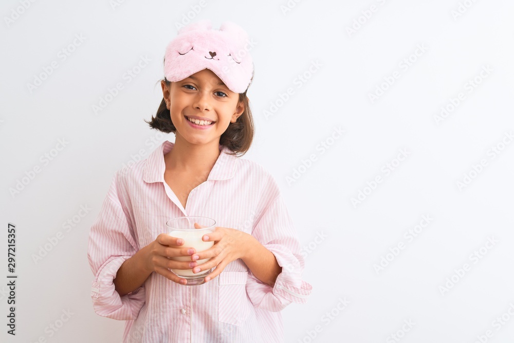 Sticker child girl wearing sleep mask and pajama drinking glass of milk over isolated white background with 