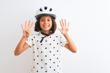 Beautiful child girl wearing security bike helmet standing over isolated white background showing and pointing up with fingers number nine while smiling confident and happy.