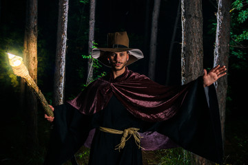 Young wizard showing magic on halloween night with his magic wand