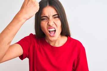 Young beautiful woman wearing red casual t-shirt standing over isolated white background annoyed and frustrated shouting with anger, crazy and yelling with raised hand, anger concept