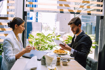 Young business couple meeting with tech devices