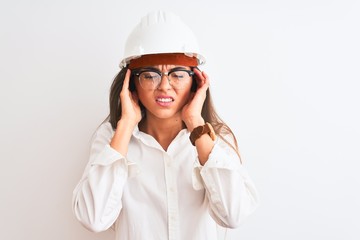 Young beautiful architect woman wearing helmet and glasses over isolated white background with hand on head for pain in head because stress. Suffering migraine.