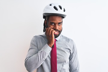 African american businessman with braids wearing bike helmet over isolated white background looking stressed and nervous with hands on mouth biting nails. Anxiety problem.