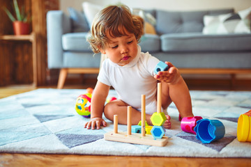 Beautiful toddler child girl playing with toys on the carpet