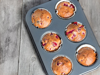 Freshly baked cherry muffins closeup in baking tray