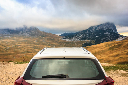 Autumn mountain landscape. View from behind a white car. Durmitor National Park, Montenegro. Focus on the car