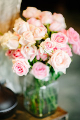 A vase of flowers filled with pink roses