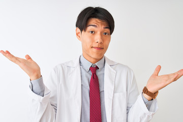 Chinese scientist man wearing tie and coat standing over isolated white background clueless and confused expression with arms and hands raised. Doubt concept.