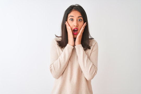 Beautiful chinese woman wearing turtleneck sweater standing over isolated white background afraid and shocked, surprise and amazed expression with hands on face