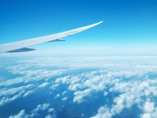 Fototapeta na wymiar Wing of airplane flying against blue sky