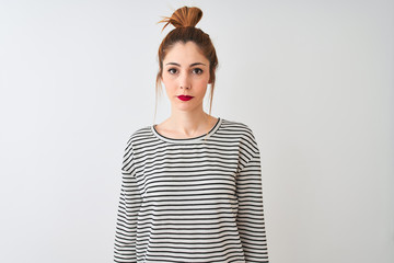 Redhead woman wearing navy striped t-shirt standing over isolated white background Relaxed with serious expression on face. Simple and natural looking at the camera.