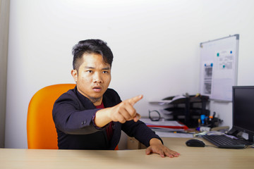 Fototapeta premium Arguing, conflict, business concept. The conflict between boss and employees. Young Asian man as boss or manager give a command with angry, mad face expression in office.