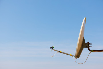 Satellite dish antenna for home TV over blue sky background