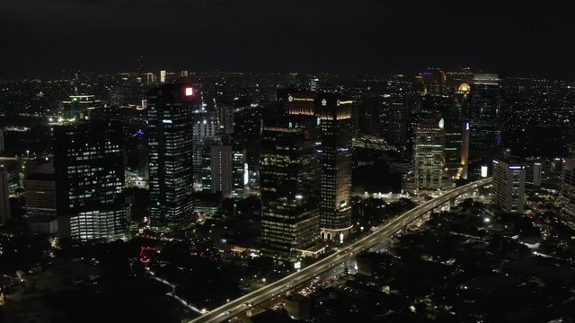 Stunning night aerial view of Jakarta City from the sky, beautiful cityscape with skyline and evening traffic of Casablanca Flyover. top down slider view