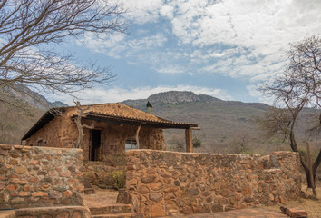 Fototapeta na wymiar An old stone cottage at the base of a mountain image with copy space in horizontal format