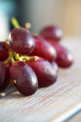 macro view on bunch of red grapes on wooden table