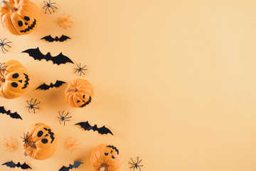 Top view of Halloween crafts, orange pumpkin, white ghost, bat and spider on orange background with copy space for text. halloween concept.