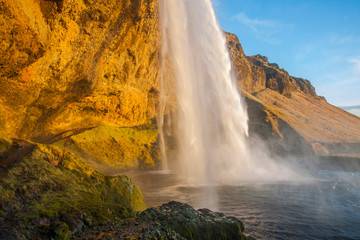 Waterfall Seljalandsfoss (part of Seljalands river taking its origin in Eyjafjallajökull volcano glacier) in southern Iceland, as seen in sunset hour