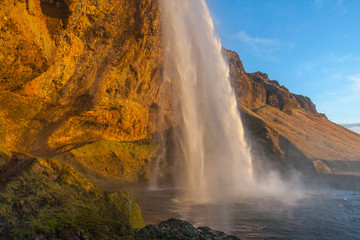 Waterfall Seljalandsfoss (part of Seljalands river taking its origin in Eyjafjallajökull volcano glacier) in southern Iceland, as seen in sunset hour