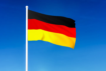 Waving flag of Germany on the blue sky background