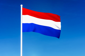 Waving flag of Netherlands on the blue sky background