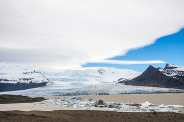 Tongue of the Breiðamerkurjökull glacier as it retreats into glacier lagoon Jökulsárlón leaving floating icebergs (Vatnajökull National Park in Iceland)