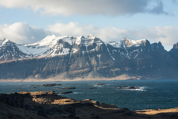 Icelandic fjords in Eastern part of island as pictured with snowstorm clouds and snow covered mountain ranges in the background
