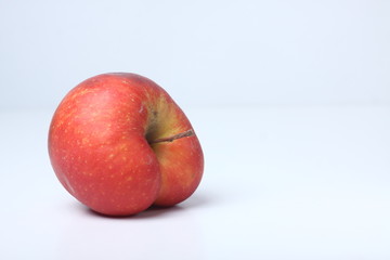 Fototapeta na wymiar Concept of ugly food - red apple on white background