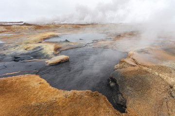 Panorama of geothermal area Hverarönd (Hverir), situated by the orange-red clay coloured tuff mountain Namafjall south of Námaskarð in Iceland, with details and patterns