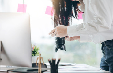 Young designer taking photo with camera while working with her new project at modorn office.