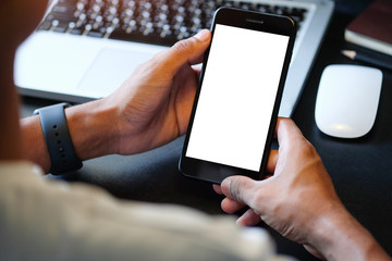 Cropped shot view of man hands holding smart phone with blank copy space screen for your text message or information content, female reading text message on cell telephone during in urban setting. 