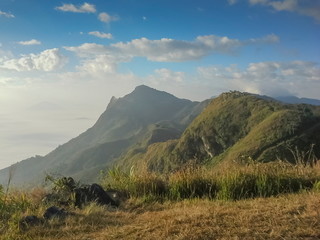 Mountain view morning of peak mountain around with soft fog with cloudy sky background, sunrise at Pha Tang, Chiang Rai, Thailand.