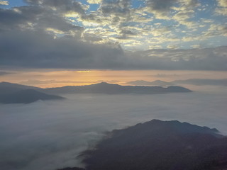 Mountain view morning of top hills around with sea of mist with cloudy sky background, sunrise at Pha Tang, Chiang Rai, northern of Thailand.