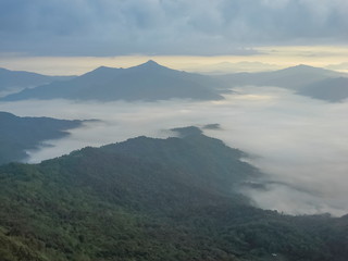 Mountain view morning of top hills around with sea of mist with cloudy sky background, sunrise at Pha Tang, Chiang Rai, northern of Thailand.