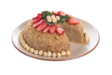 Medovik – Russian layer honey cake with delicious sour cream frosting. Garnished with hazelnuts and strawberry slices 