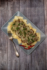 Beshbarmak is a national Kazakh dish - square pasta with boiled meat and onions. On wooden...