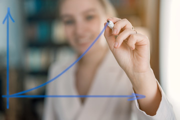 girl draws a graph a marker on glass