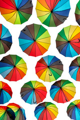 Many multicolored umbrella floating on white