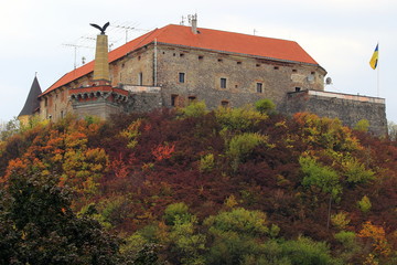 Palanok Castle or Mukachevo Castle. Ukraine. Beautiful landscape with a medieval Mukachevo castle on a mountain among colorful fall foliage on a cloudy day.