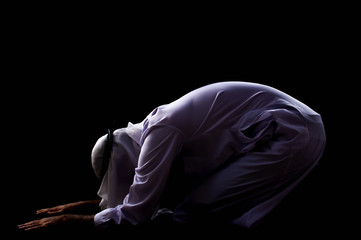 A muslim man is praying with dark background