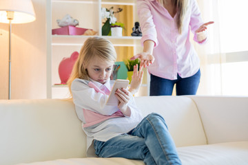 Mother asking her daughter put down the smartphone