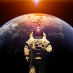 standing astronaut in front of planet Earth © dottedyeti