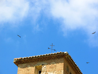 eagles in the sky above the roof of old spanish church