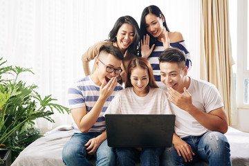 Vietnamese young people laughing when watching videos online on laptop screen