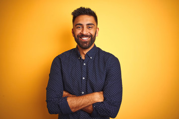 Young handsome indian businessman wearing shirt over isolated yellow background happy face smiling...