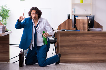 Young drunk employee in the office