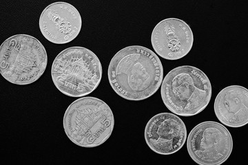 Thai Baht coins on a dark background close-up, black and white