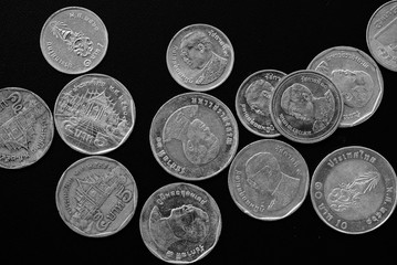 Thai Baht coins on a dark background close-up, black and white