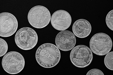 Thai Baht coins on a dark background close-up, black and white
